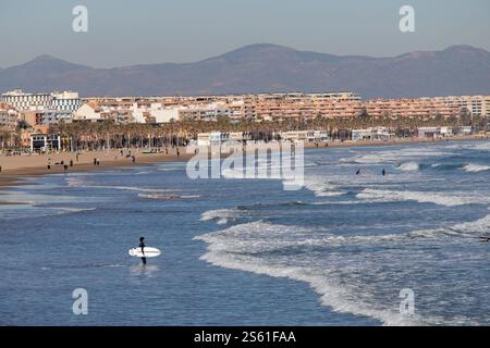 Valence, Espagne, 15 janvier 2025. Surfeurs et touristes s'amusant à Las Arenas plage. Cette année, le magazine Forbes a déclaré Valence la meilleure ville au monde à prendre sa retraite. Crédit : Eduard Ripoll. Banque D'Images