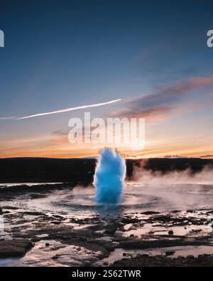 Éruption de Strokkur Geysir au coucher du soleil dans le sud de l’Islande, dans la vallée de Haukadalur Banque D'Images