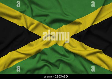 Le drapeau de la Jamaïque est représenté sur un tissu de sport avec de nombreux plis. Bannière agitant l'équipe sportive. Drapeau de la Jamaïque est représenté sur un tissu de tissu de sport avec Banque D'Images