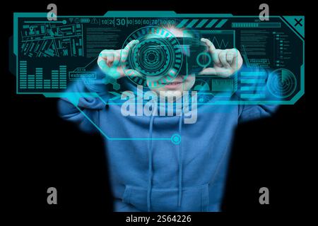 Fille en sweat à capuche bleu avec casque de réalité virtuelle utilisant l'interface virtuelle HUD sur fond noir. Lunettes de réalité virtuelle. Cyberespace, divertissement Banque D'Images
