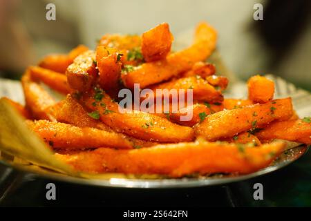Gros plan de frites de patates douces assaisonnées de sel et d'herbes Banque D'Images
