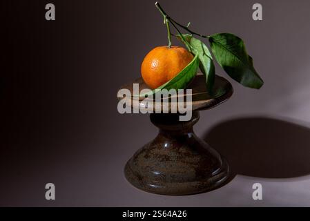 mandarine avec feuille verte sur support à gâteau Banque D'Images