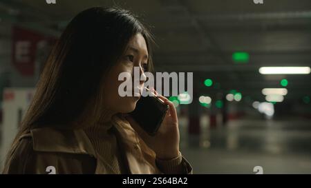 Inquiet bouleversé femme asiatique parler téléphone mobile dans le stationnement appel inquiet parler déçu smartphone conversation problème d'affaires chinoise coréenne fille Banque D'Images