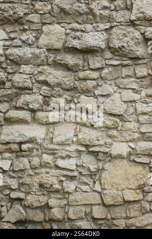 Texture d'un mur de pierre avec beaucoup de grosses pierres brunes et grises armées de ciment. Vieux château mur de pierre texture fond pour usage médiéval. Partie d'un Banque D'Images