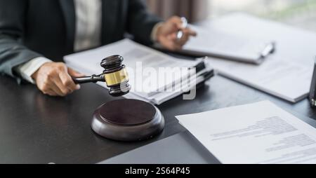 Avocat homme d'affaires travaillant avec Lawbook dans le bureau ou le conseil juridique de salle d'audience avec marteau et droit juridique. justice et avocat concept juge marteau à marteau Banque D'Images