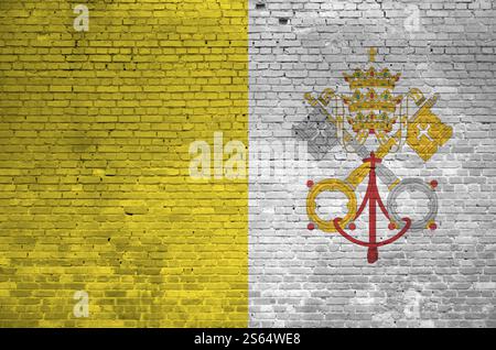 Drapeau de l'État de la Cité du Vatican représenté en couleurs de peinture sur un vieux mur de briques en gros plan. Bannière texturée sur le fond de maçonnerie de mur de briques. État de la Cité du Vatican Banque D'Images