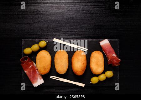 Croquettes au jambon sur une assiette rectangulaire en ardoise avec un espace négatif sur le dessus Banque D'Images
