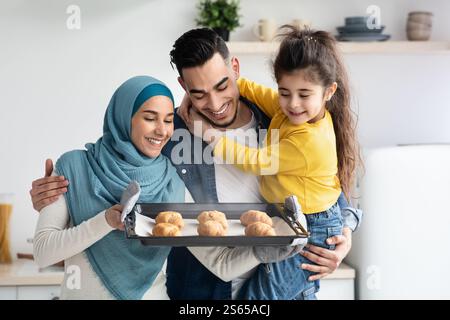 Bonne famille musulmane de trois plateaux de conservation avec croissants dans la cuisine Banque D'Images