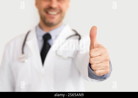 Portrait d'un médecin adulte montrant les pouces jusqu'à l'appareil photo Banque D'Images