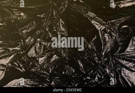 Texture du sac jetable à ordures en plastique noir gros plan. Texture du sac jetable à ordures en plastique noir Banque D'Images