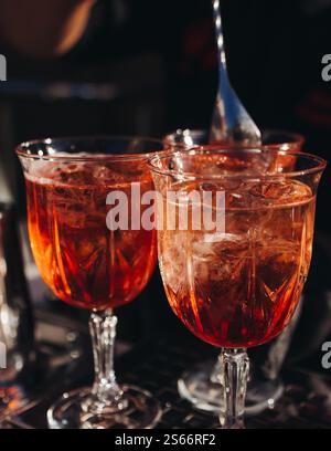 Barman travaillant, belle ligne de rangée de cocktails d'alcool de différentes couleurs sur une fête en plein air dans un bar, et d'autres sur le banquet de restauration sur e. Banque D'Images