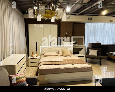 Une chambre moderne magnifiquement conçue avec des meubles blancs élégants, des accents décoratifs et un éclairage doux. L'espace dégage une vib épurée et minimaliste Banque D'Images