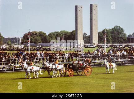 Berlin, Allemagne. 24 mai 1985. Monarque britannique la reine Elizabeth II, le prince Philip et le prince Édouard assis dans une voiture royale ouverte lors de leur visite d'État à Berlin le 24 mai 1985. Le chariot est tiré par des chevaux, et le stade olympique est visible en arrière-plan. L'image capture un moment de l'apparition de la famille royale devant la foule lors de cette importante visite d'État en Allemagne. La visite a eu lieu à un moment où l'Allemagne était encore un pays divisé pendant la guerre froide. Banque D'Images
