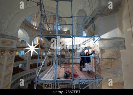 Dresde, Allemagne. 16 janvier 2025. Les restaurateurs se tiennent sur les échafaudages pendant les travaux d’entretien et de nettoyage dans la Frauenkirche et travaillent sur les chapiteaux en stuc des piliers de l’abside nord. Environ 40 artisans, restaurateurs et nettoyeurs travaillent dans l'église, qui rouvrira régulièrement à partir du 19 janvier 2025. Crédit : Sebastian Kahnert/dpa/Alamy Live News Banque D'Images