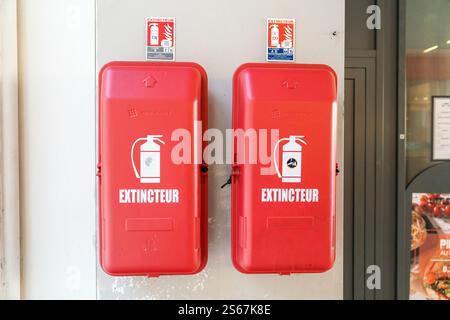 Extincteurs rouges montés sur un mur à l'extérieur d'un bâtiment commercial Banque D'Images