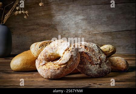 différents types de pain fraîchement cuit sur la table en bois rustique dans la boulangerie Banque D'Images