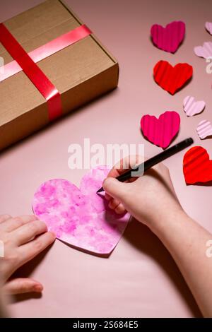 Plan vertical d'une femme créant une carte de Saint-Valentin. Carte de vœux avec la phrase « Be my valentine ». Concept de la Saint-Valentin. Banque D'Images