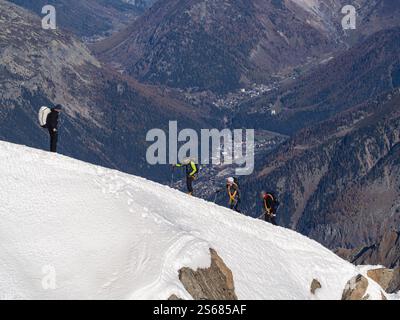 Grimpeurs gravissent les pentes escarpées et enneigées de l’aiguille du midi – Un défi alpin pur au cœur de Chamonix Banque D'Images