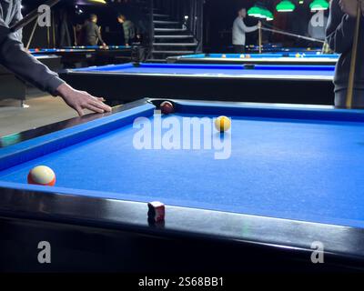 Les joueurs profitent d'un jeu de billard animé dans une atmosphère de bar intérieur dynamique Banque D'Images
