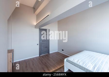 Chambre lumineuse et contemporaine aux tons gris doux, parquet et décoration minimaliste pour une esthétique moderne. Mettre en valeur une atmosphère propre Banque D'Images