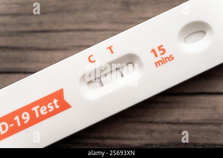 Résultat positif du test rapide d’antigène Covid-19 | Un gros plan macro d’une cassette de test d’antigène rapide montre deux lignes violettes dans la fenêtre de résultat, marquées C pour contrôle et T pour test, indiquant un résultat positif pour le SARS-CoV-2. Les tests de flux latéral de ce type détectent les protéines virales en environ 15 minutes et sont devenus un incontournable des tests à domicile pour la détection du Covid-19 pendant la pandémie. Banque D'Images