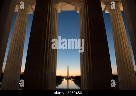 WASHINGTON DC, États-Unis — la lumière avant l'aube illumine le Washington Monument vu à travers la colonnade orientale du Lincoln Memorial. La vue Banque D'Images