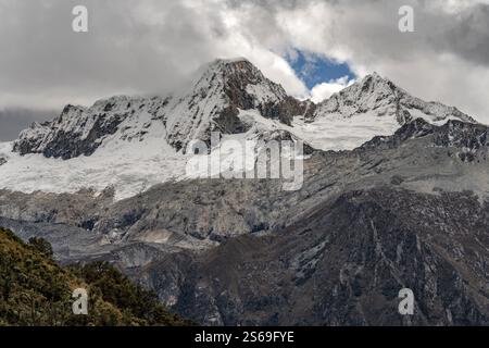 Paysage hivernal à couper le souffle avec des montagnes enneigées sous un beau ciel brumeux. Banque D'Images