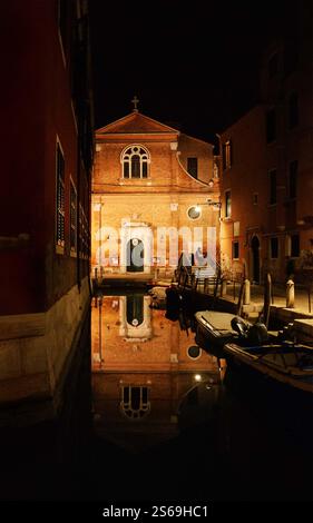 Réflexions du paysage de Venise. Église San Martino reflétée dans l'eau du canal la nuit en hiver. Venise, Italie. Banque D'Images