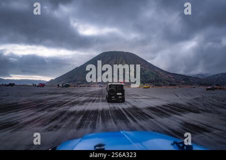 Découvrez la vue imprenable sur le mont bromo, un volcan majestueux au milieu d'un terrain accidenté et d'un ciel spectaculaire rempli de nuages dans cette superbe image, Banque D'Images