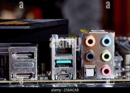 Gros plan détaillé d'une carte mère d'ordinateur, présentant divers ports, y compris Ethernet, USB, HDMI et connexions audio. Idéal pour illustrer t Banque D'Images