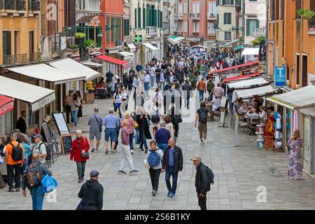 Venise, Italie - 09 octobre 2024 : de nombreux touristes marchant dehors à travers les rues de Venise pendant la journée ensoleillée avec des façades de bâtiments anciens dans le dos Banque D'Images
