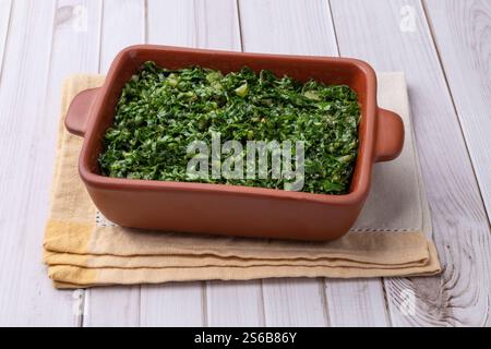 Bandes de chou frisé cuites, plat typique brésilien feijoada dans une assiette sur une table en bois. Banque D'Images