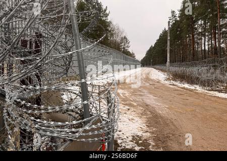 Polowce, Pologne. 16 janvier 2025. Un chemin mène le long du côté polonais de la clôture à la frontière avec la Biélorussie. La clôture à la frontière extérieure de l'UE a été érigée pour empêcher le franchissement illégal des frontières. La Pologne accuse la Biélorussie et la Russie de faire passer délibérément clandestinement des migrants à la frontière afin de déstabiliser l'UE. Crédit : Ansgar Haase/dpa/Alamy Live News Banque D'Images
