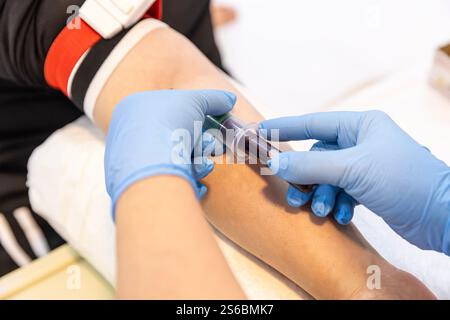 Médecin ou infirmière prélevant un échantillon de sang dans la veine du bras avec un vacutainer. Ponction veineuse ou ponction veineuse. Une infirmière dans le laboratoire prend un test sanguin f Banque D'Images