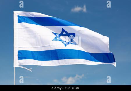 Drapeau national d'Israël flotte sur le mât contre le ciel bleu Banque D'Images