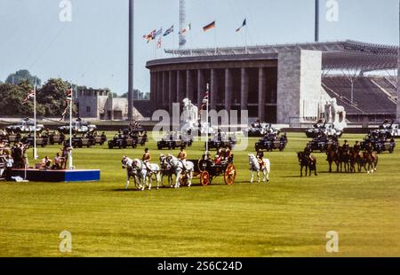 Berlin, Allemagne. 24 mai 1985. Monarque britannique la reine Elizabeth II, le prince Philip et le prince Édouard assis dans une voiture royale ouverte lors de leur visite d'État à Berlin le 24 mai 1985. Le chariot est tiré par des chevaux, et le stade olympique est visible en arrière-plan. L'image capture un moment de l'apparition de la famille royale devant la foule lors de cette importante visite d'État en Allemagne. La visite a eu lieu à un moment où l'Allemagne était encore un pays divisé pendant la guerre froide. Banque D'Images