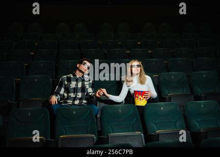 Couple aime une soirée de rendez-vous de cinéma avec pop-corn dans un théâtre Banque D'Images