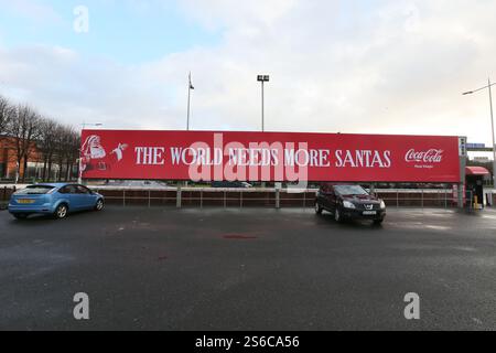 Belfast, Irlande du Nord - décembre 2024 - Un grand panneau Coca Cola avec une photo du Père Noël et les mots « le monde a besoin de plus de santas » visibles depuis une rue du centre-ville de Belfast pendant les derniers jours avant Noël. Banque D'Images