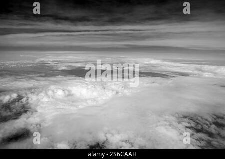 Une photo en noir et blanc d'un ciel nuageux avec quelques nuages. Le ciel est principalement gris et les nuages sont dispersés dans tout le ciel Banque D'Images