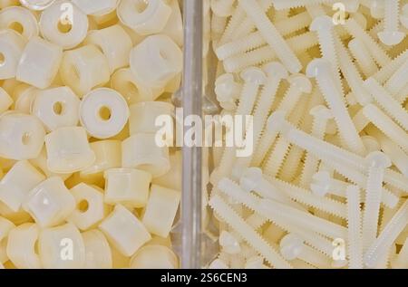 Écrous et boulons en nylon en plastique blanc boulonnerie de vis mécaniques accessoires divisés d'outils de travail. Banque D'Images