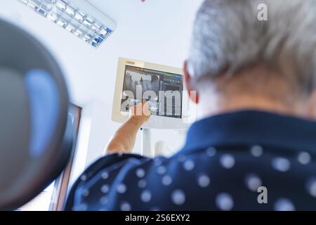 Un homme pointe vers un écran avec une radiographie dans une salle médicale moderne, cabinet dentaire, Allemagne, Europe Banque D'Images