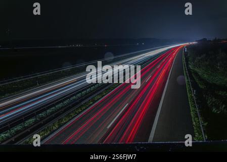 Longue exposition d'une autoroute la nuit avec des traînées de lumière rouge et blanche représentant la vitesse et le mouvement, Kirchroth, basse-Bavière Banque D'Images