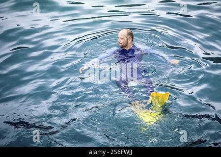 Une image d'un homme nageant dans son safetysuit Banque D'Images