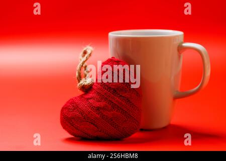 Une délicieuse combinaison d'une tasse de café vapeur et d'un cadeau en forme de cœur, idéal pour les moments de la Saint-Valentin ou les gestes romantiques Banque D'Images