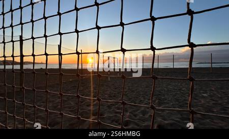 Terrain de football dans le sable à la plage pendant le lever du soleil Banque D'Images