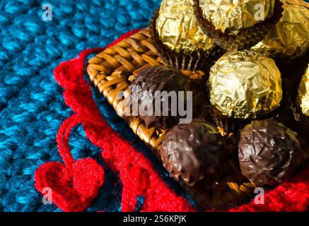 Chocolats et coeurs tricotés pour la Saint-Valentin. Fait à la main à partir de fil rouge pour les vacances. Banque D'Images