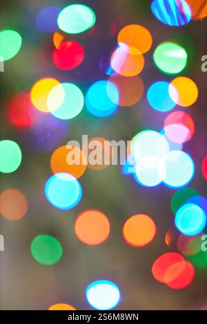 Les lumières bokeh festives de différentes couleurs créent un arrière-plan vibrant et joyeux. L'image présente des formes circulaires floues en vert, rouge, bleu, orange, Banque D'Images