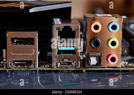 Gros plan détaillé d'une carte mère d'ordinateur, présentant divers ports, y compris Ethernet, USB, HDMI et connexions audio. Idéal pour illustrer t Banque D'Images