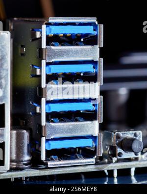 Macro-plan détaillé de plusieurs ports USB 3,0 sur une carte mère d'ordinateur, mettant en évidence les connecteurs bleus et le boîtier métallique. Convient pour l'illustration Banque D'Images