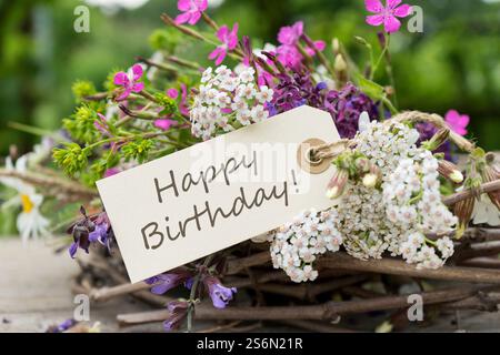 Carte d'anniversaire avec couronne et bouquet de fleurs colorées de prairie Banque D'Images
